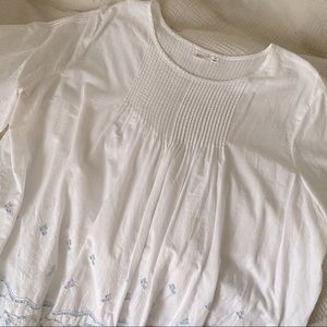 White shortsleeved peasant top with light blue embroidery